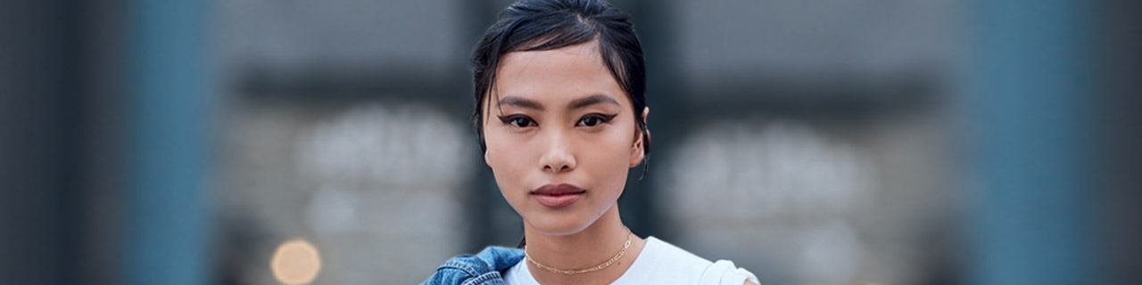 Bannière - portrait d'une femme portant eyeliner avec jean sur les épaules 